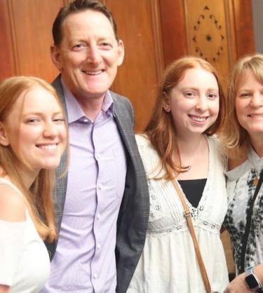 Four smiling people posing for photo