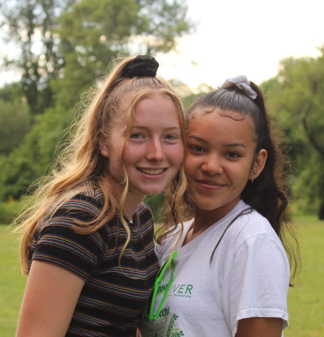Two smiling teenage girls posing outdoors