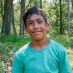 Smiling boy in teal shirt outdoors