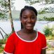 Smiling girl in red shirt by lake