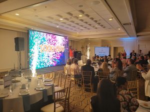 Banquet hall celebration with large colorful screen