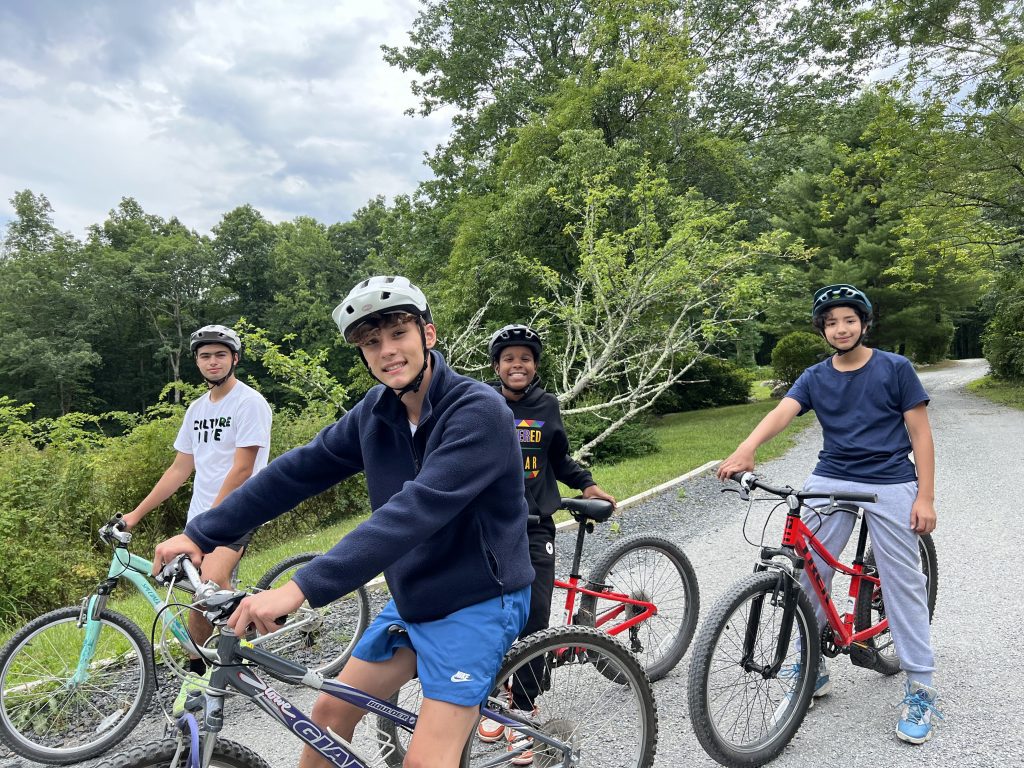 Four teens cycling outdoors on paved path