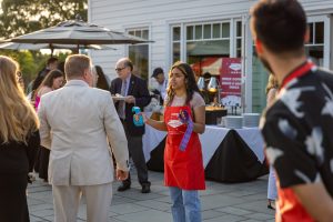 Woman in red apron giving ribbon at event
