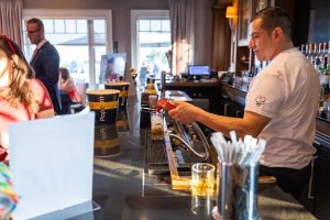 Bartender pouring drink at busy bar
