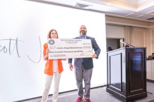Two people holding oversized ceremonial check