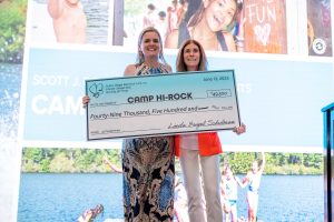 Two women holding oversized Camp Hi-Rock check.