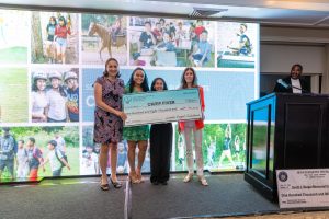 Group holding giant ceremonial check onstage