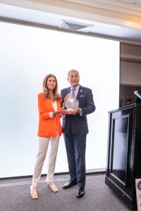 Man and woman holding award on stage