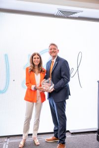 Two professionals holding glass award smiling