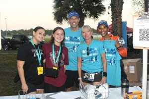 Smiling runners and volunteers at race registration