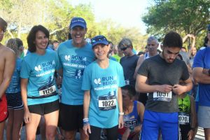 Group of runners in blue race shirts smiling