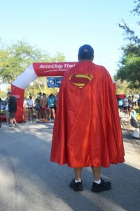 Person in Superman cape at race start