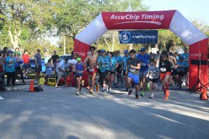 Runners starting race under inflatable timing arch
