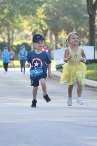 Two children running in playful costumes