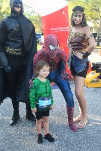 Child posing with superheroes at outdoor event