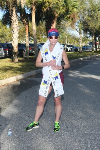 Runner standing on road wearing finisher sash