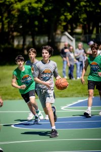 Teen dribbling basketball on outdoor court