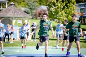 Teens playing outdoor basketball near gazebo