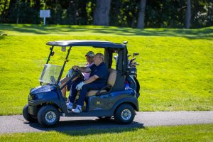 Two golfers riding in a golf cart