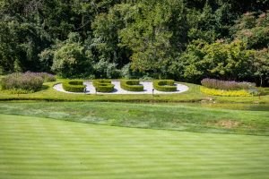 Ornamental circular hedges beside pond