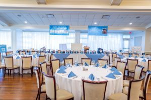 Banquet room with round tables and blue napkins