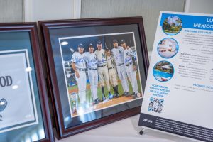 Framed Yankees team photo beside travel poster
